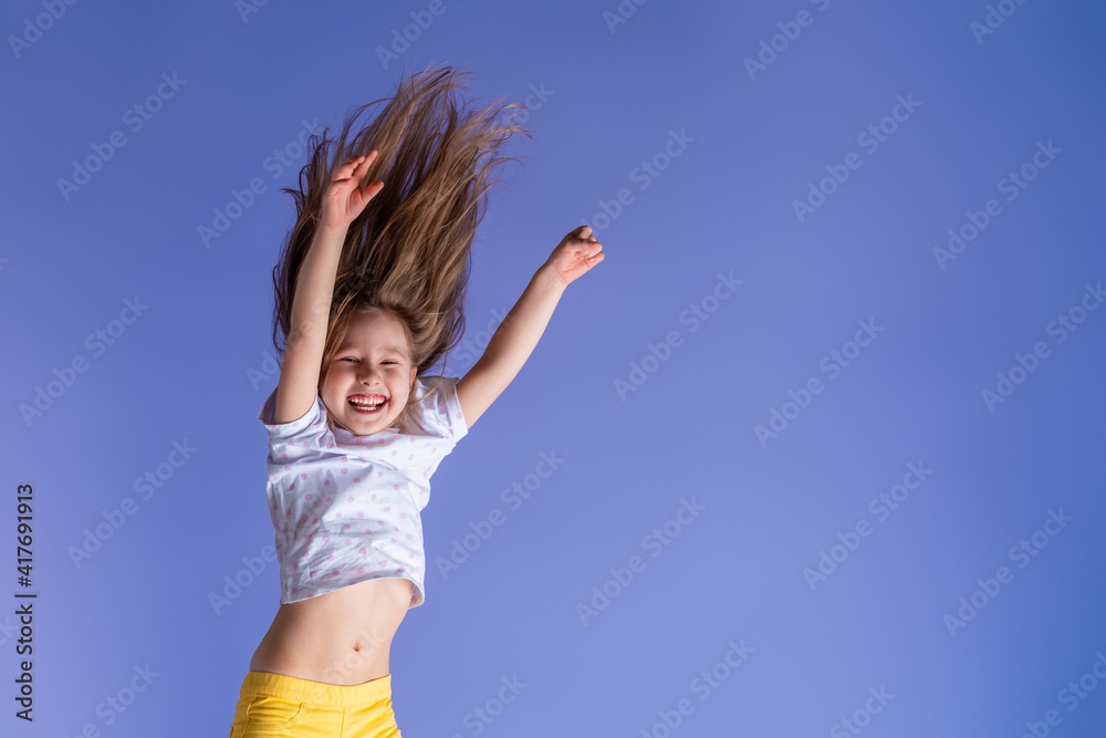 crazy excited little fun girl hanging happy upside down hands up on isolated purple studio background. Dynamic children's image. Emotions, expression. Copy space crazy excited little fun girl hanging happy upside down hands up on isolated purple studio background. Dynamic children's image. Emotions, expression. Copy space