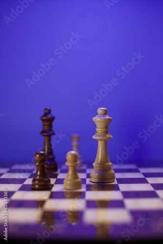 chess pieces and glossy chessboard. close up and blurry view