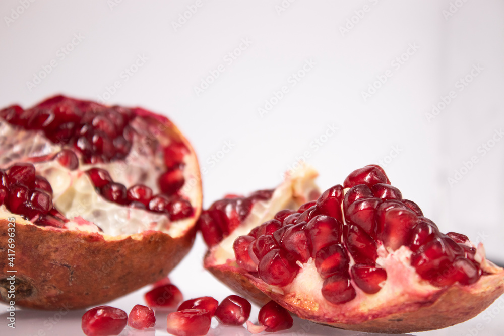 ripe fresh sliced pomegranate fruit with red seeds isolated on white background ripe fresh sliced pomegranate fruit with red seeds isolated on white background