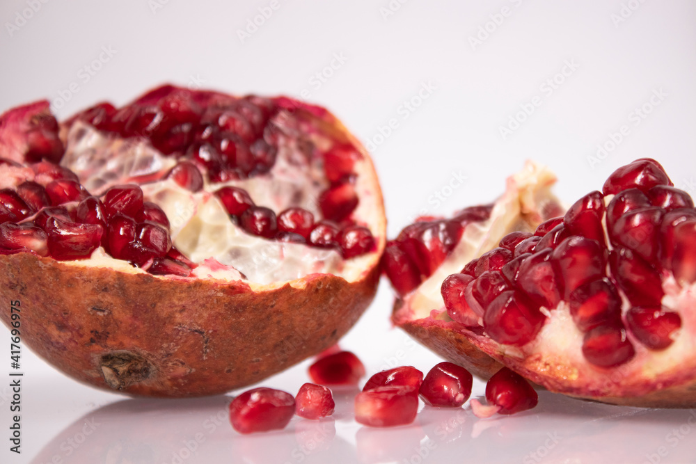 ripe fresh sliced pomegranate fruit with red seeds isolated on white background ripe fresh sliced pomegranate fruit with red seeds isolated on white background