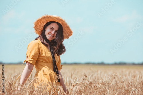 woman in yellow sundress walking by wheat field