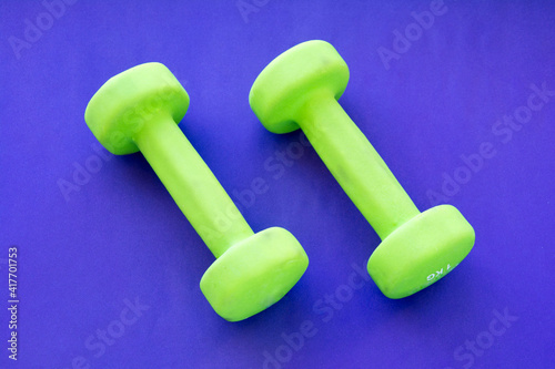 Small rubberized dumbbells 1 kg on a purple background