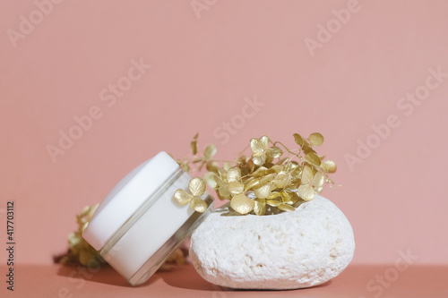 Cosmetics container mockup. White moisturizing cream jar and on trendy pink background. Natural organic cosmetics concept.