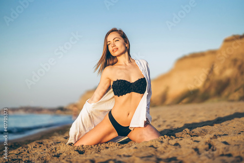 Pretty brunette woman relaxing on the beach at the sea.