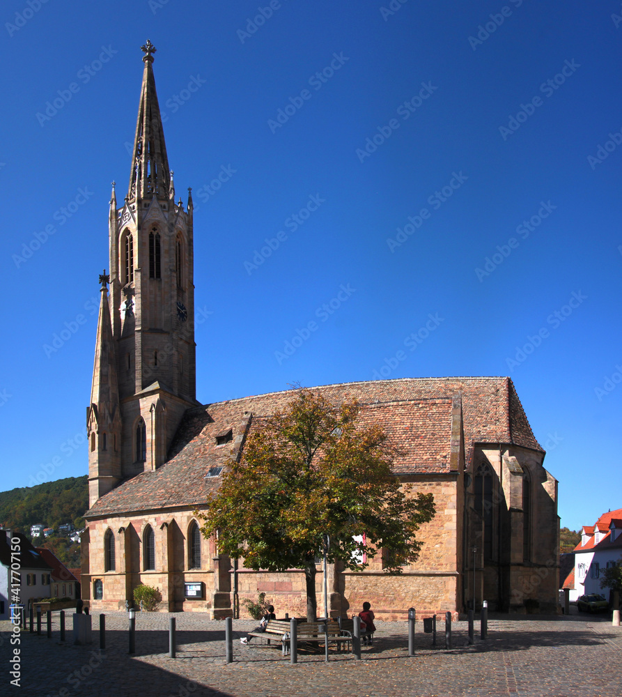 Obraz premium Gothic Schlosskirche church with its pointed steeple and a city square in the old town of Bad Dürkheim in Germany