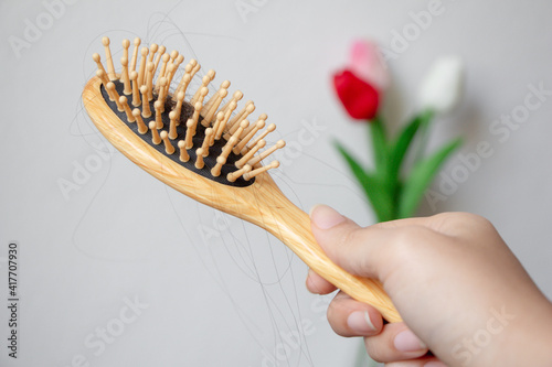 Young Asian woman with hair comb on white background, closeup problem hair. 