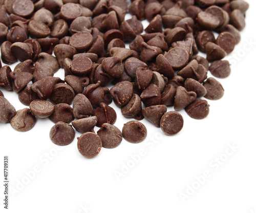 Close up pile of chocolate morsels on white background