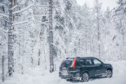 SUV driving through a snowy forest