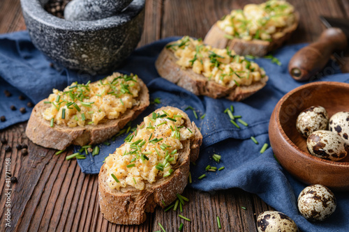 Healthy breakfast, scrambled quail eggs topped with chopped chives