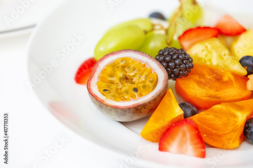 Fruit plate of fresh fruit slices for breakfast. On a white plate  passionfruit 