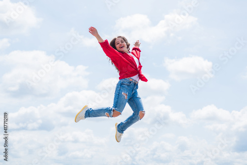 happy energetic kid feeling free and jumping high, freedom