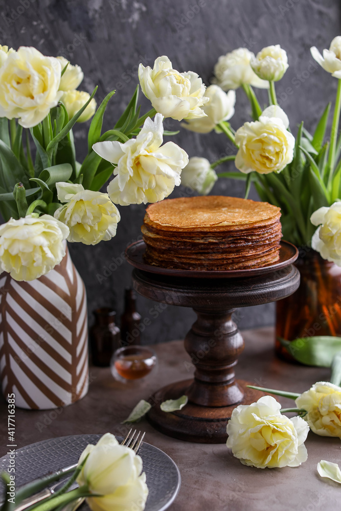 Obraz premium Rice pancakes on the table with a bouquet of tulips. Spring decoration of the dining table. Still life with flowers.