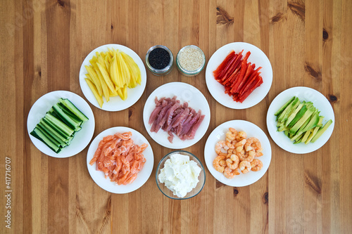 sushi ingredients placed on the wooden table. prepared for sushi making at home photo