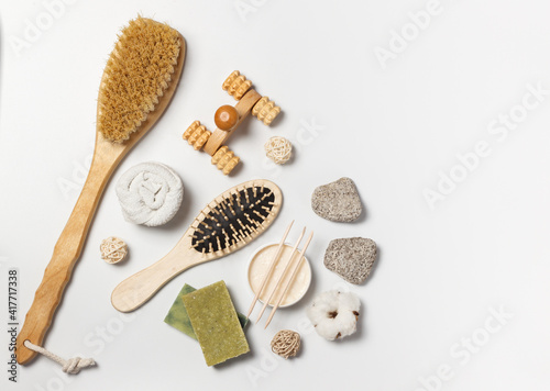 Natural soap, body scrub, body cream and wooden accessories for the care of skin and hair. Layout on a white background with space