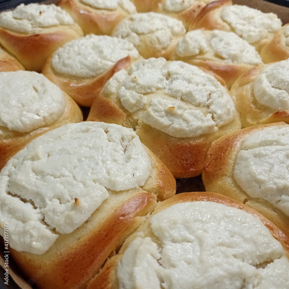 Homemade delicious buns with cottage cheese on a baking sheet