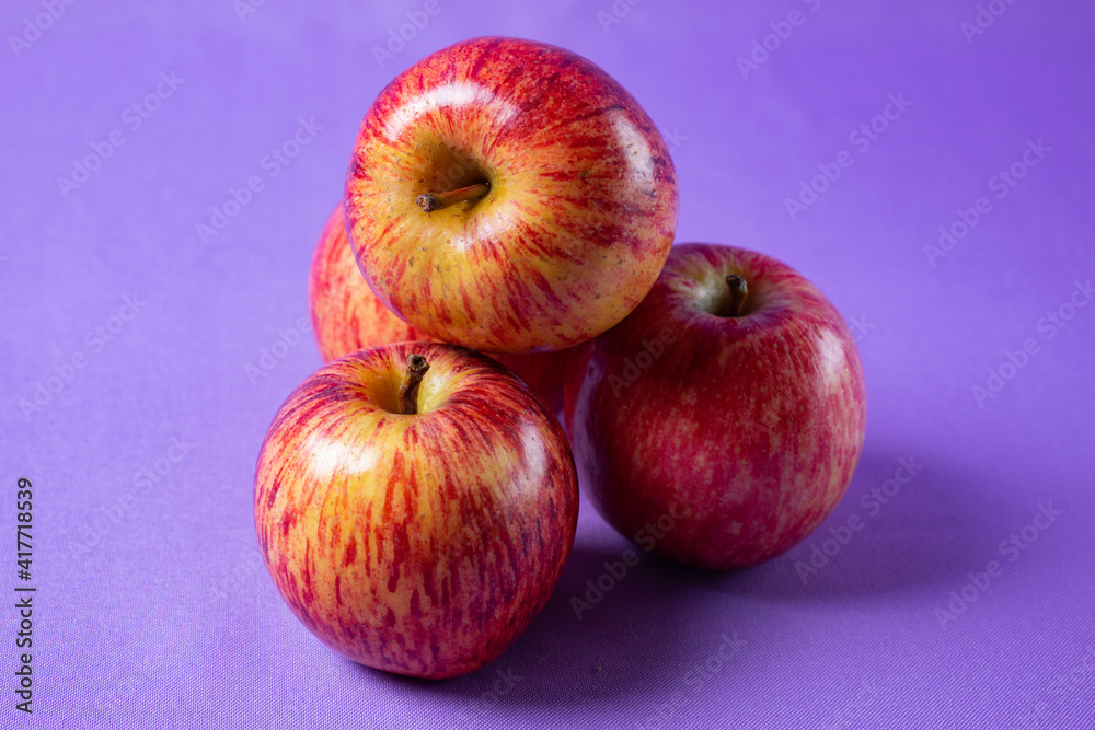bright red apples on lilac background bright red apples on lilac background
