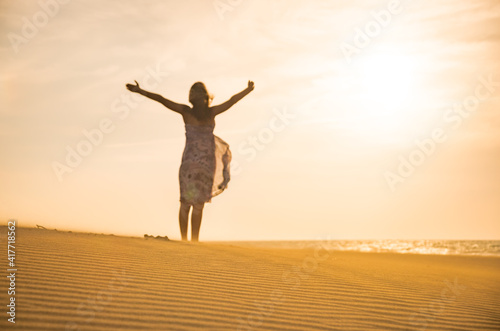 Freedom and happiness. Along young woman on sand enjoying sun, nature.