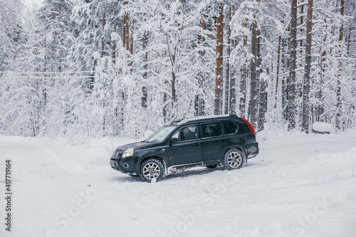 SUV driving through a snowy forest © Erika Parfenova