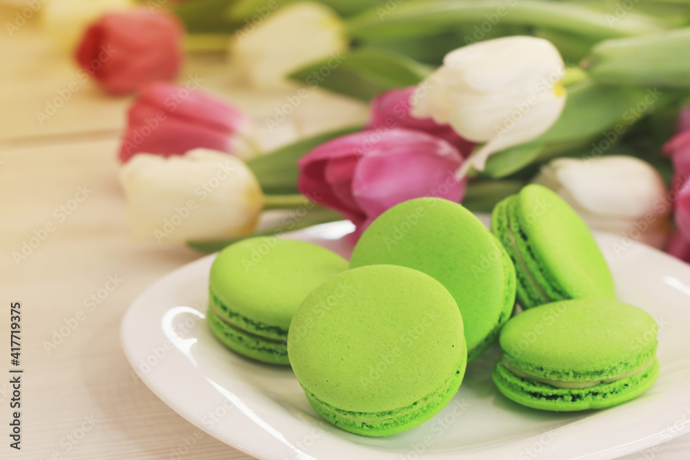 Tasty macaroons and flowers on light background Tasty macaroons and flowers on light background