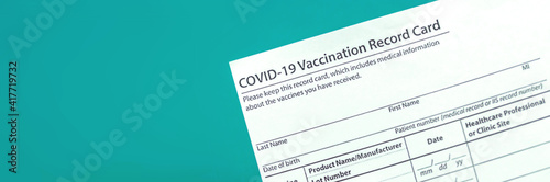 COVID-19 vaccination record card close up banner, copy space