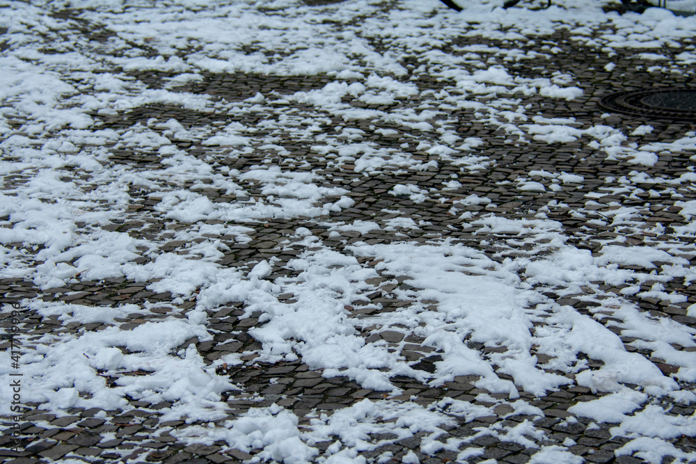 Obraz premium Non maintained snowy stone sidewalk during 2021 snow storm in Berlin Germany