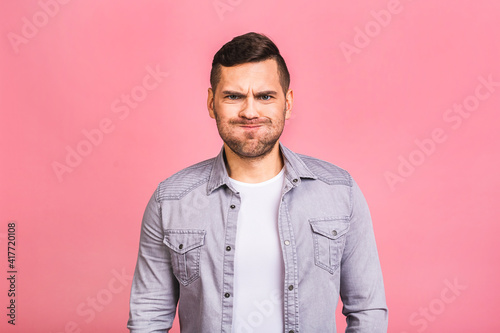 Young handsome caucasian man in casual isolated over pink background puffing cheeks with funny face. Mouth inflated with air, crazy expression.