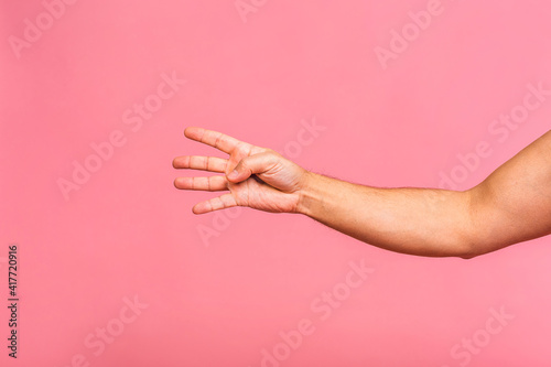 Caucasian man's hand showing different gestures isolated over pink background, closeup view of hands. Copy space for text.
