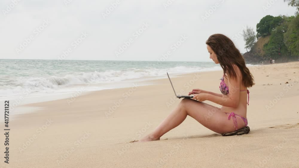 You can work from anywhere at online era. Freelancer woman using laptop for remote job, sitting on beach. She wear only bikini, hilarious trope of digital nomad lifestyle. You can work from anywhere at online era. Freelancer woman using laptop for remote job, sitting on beach. She wear only bikini, hilarious trope of digital nomad lifestyle.