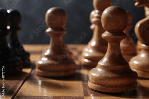 Chess is a board game. Chess pieces on a dark background