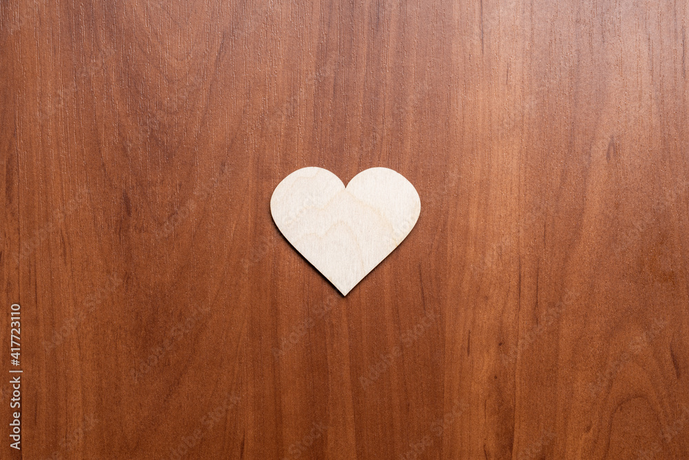 Fototapeta premium wooden heart symbol on wooden background. valentine greeting card concept. above view