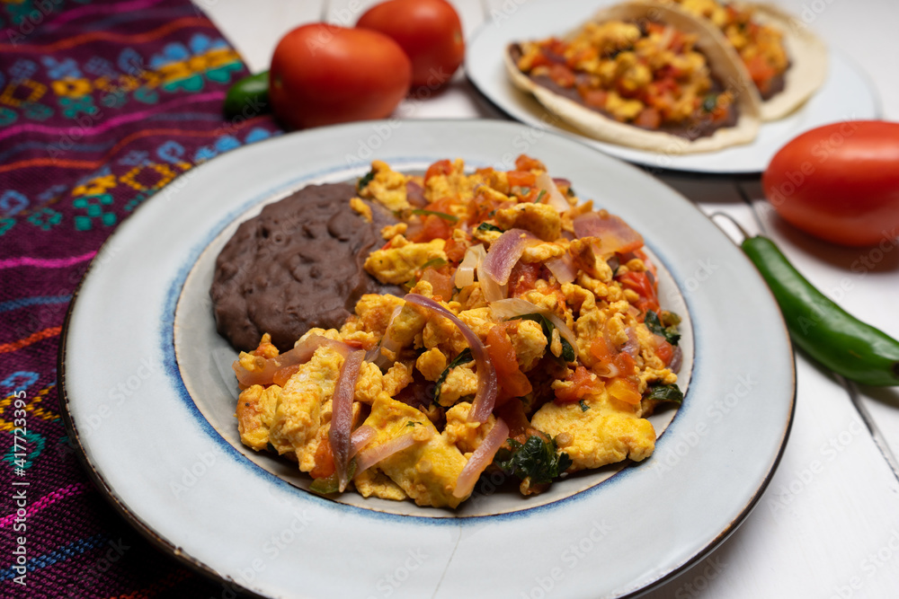 Scrambled eggs and refried beans on white background. Mexican food Scrambled eggs and refried beans on white background. Mexican food