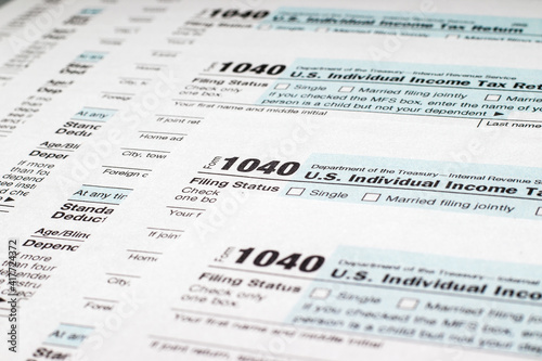 Stack of tax forms 1040. Individual income tax return. Selective focus © Igor Nikushin
