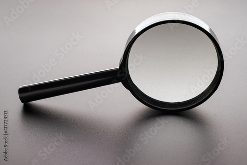 Magnifying glass with reflection on a dark matte surface