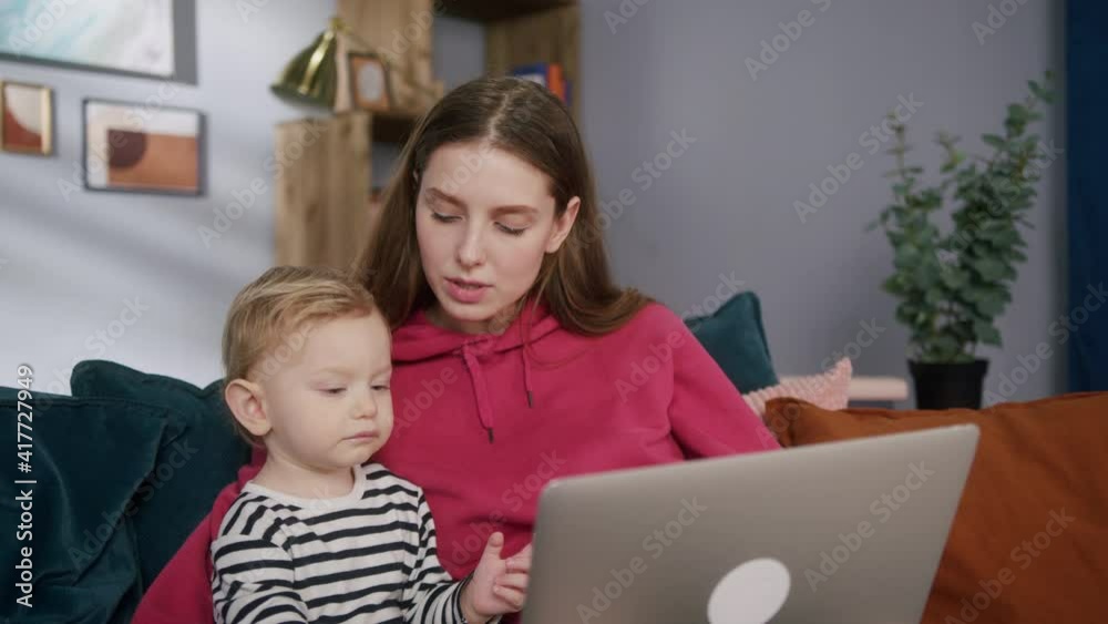Mother and son using laptop computer, cute baby kid and mom watching cartoons and having fun together Mother and son using laptop computer, cute baby kid and mom watching cartoons and having fun together