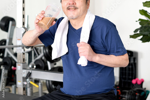 プロテインを飲む白髪のシニア男性 © koumaru