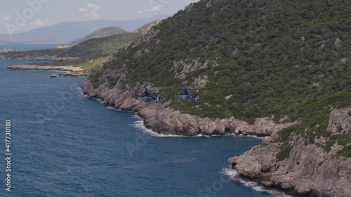 Aerial of Private Helicopters Flying by Mountains and Over Ionian Sea in Greece photo