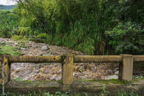 rock fence in the forest with furious river