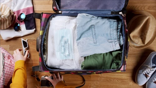 Top view of woman packing for trip holiday, desktop travel concept.