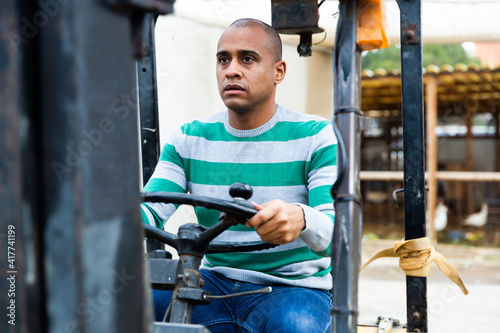 Middle aged hispanic man working on forklift at vegetable plant factory in warehouse