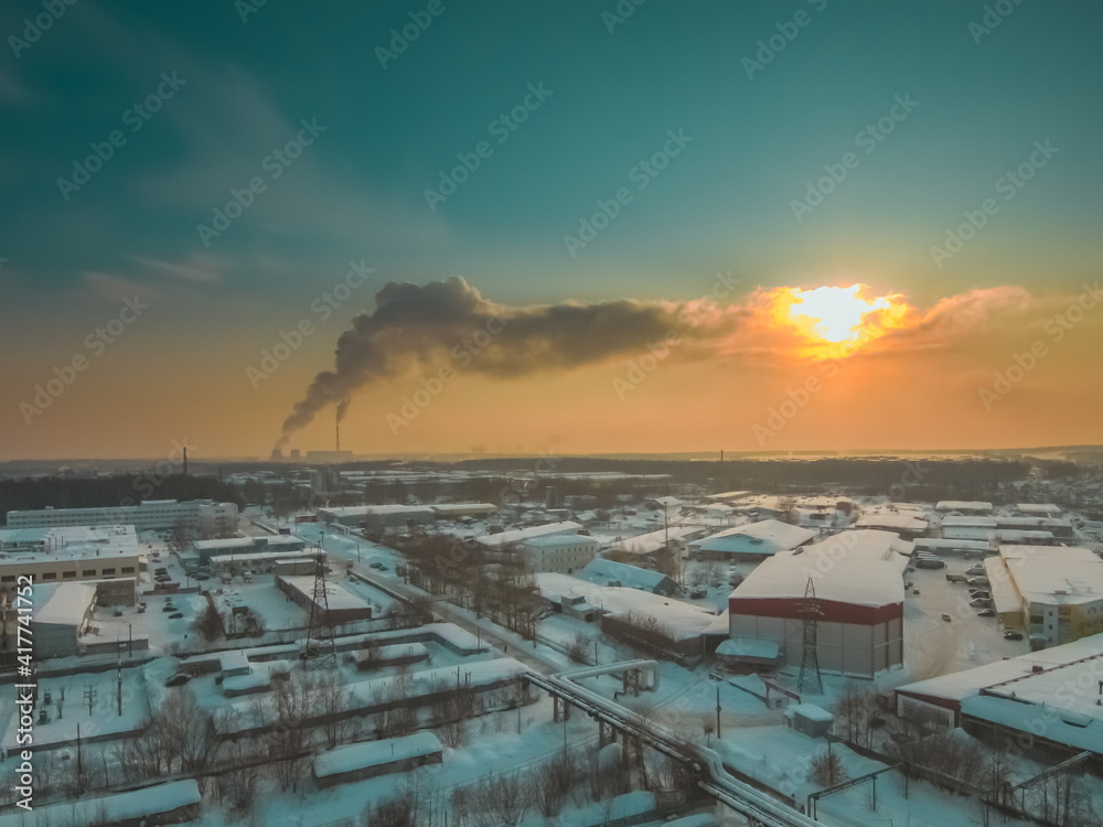 the rising sun beautifully illuminates a large city in the north of the Russian Federation on a frosty winter morning