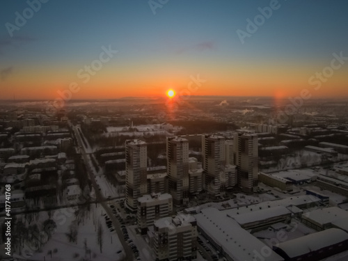the rising sun beautifully illuminates a large city in the north of the Russian Federation on a frosty winter morning