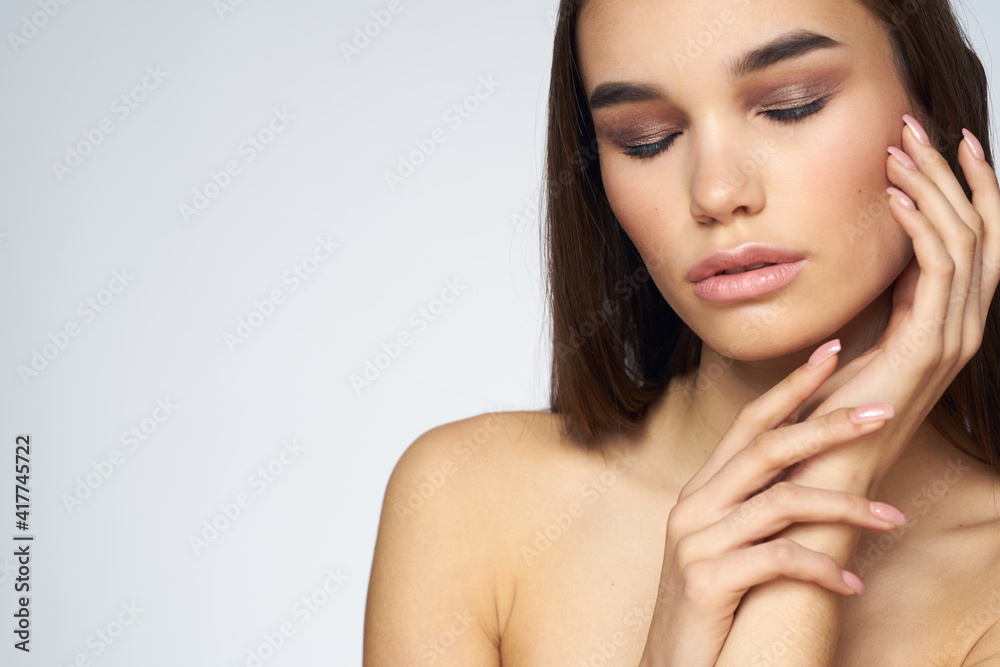 Woman with long hair bared shoulders clean skin body care light background Woman with long hair bared shoulders clean skin body care light background