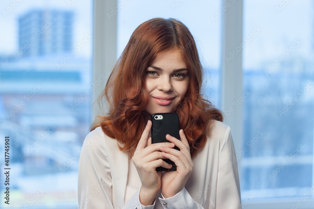 woman with phone in hands in office technology professional
