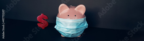 Dollar sign with pink piggy bank wearing face mask. Money ,mortgage deferral coronavirus pandemic concept. Banner panoramic crop. photo