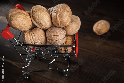 Walnuts in a metal trolley on a dark wooden background, close up, copy space