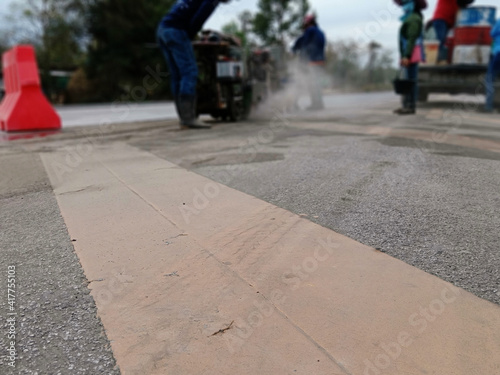 Blurred image of cutting-drilling of pavement to create an island in the middle of the road.