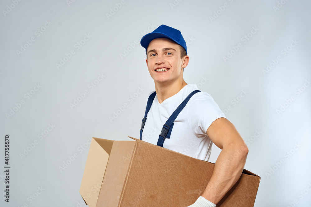 A man in a working uniform loading cardboard boxes providing services A man in a working uniform loading cardboard boxes providing services