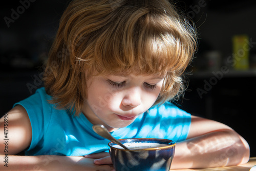 Kids nutrition. Little boy eats soup. Healthy food for children. Organic homefood. photo