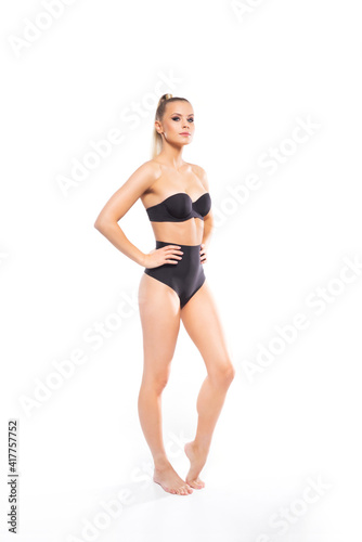 Young, fit and beautiful blond woman in white swimsuit isolated on white background. Healthcare, diet, sport and fitness.