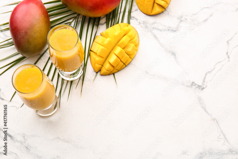 Glasses of tasty mango smoothie on light background Glasses of tasty mango smoothie on light background